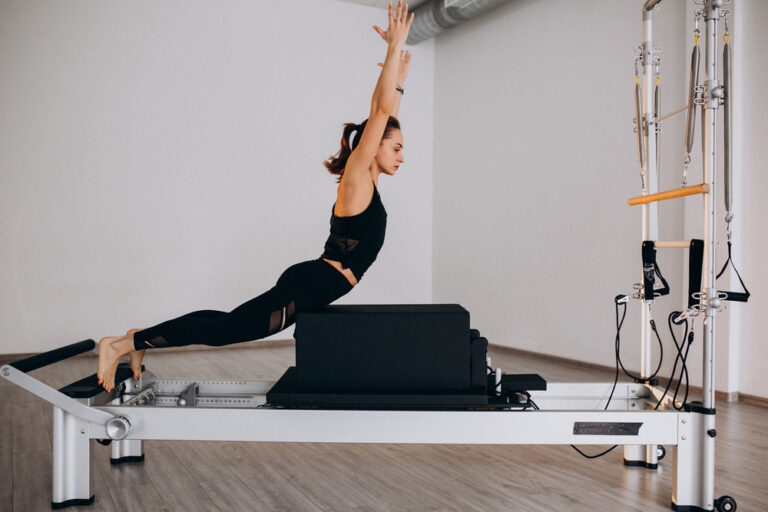 Woman,Doing,Pilates,On,A,Reformer
